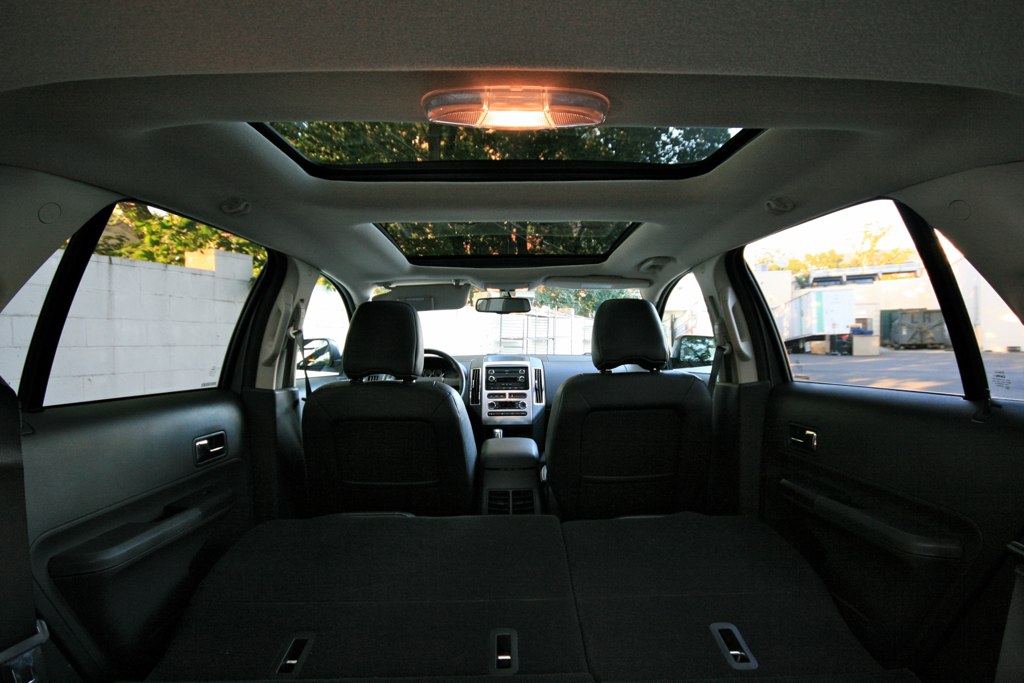 Interior de SUV visto do banco de trás, com teto panorâmico de dois vidros