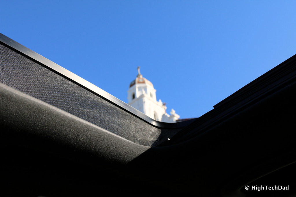 Teto solar aberto visto de dentro do carro, com céu azul